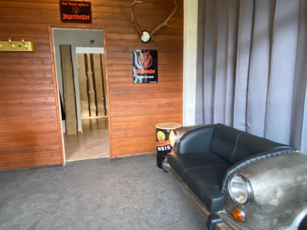 Zimmer mit Sofa vor einer Tür in der Unterkunft Hostel Harzer Hof in Hahnenklee-Bockswiese