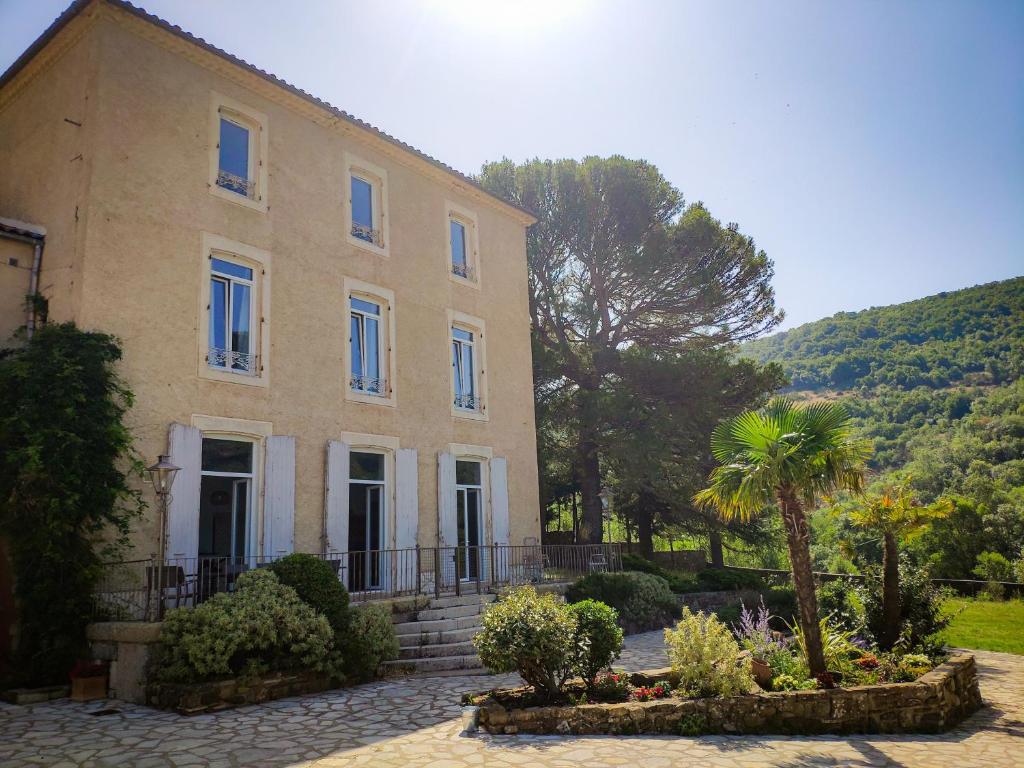 a large house with a palm tree in front of it at Le Cèdre de Prades 4 étoiles Logement entier Parc Naturel Haut Languedoc - Salagou in Dio-et-Valquières