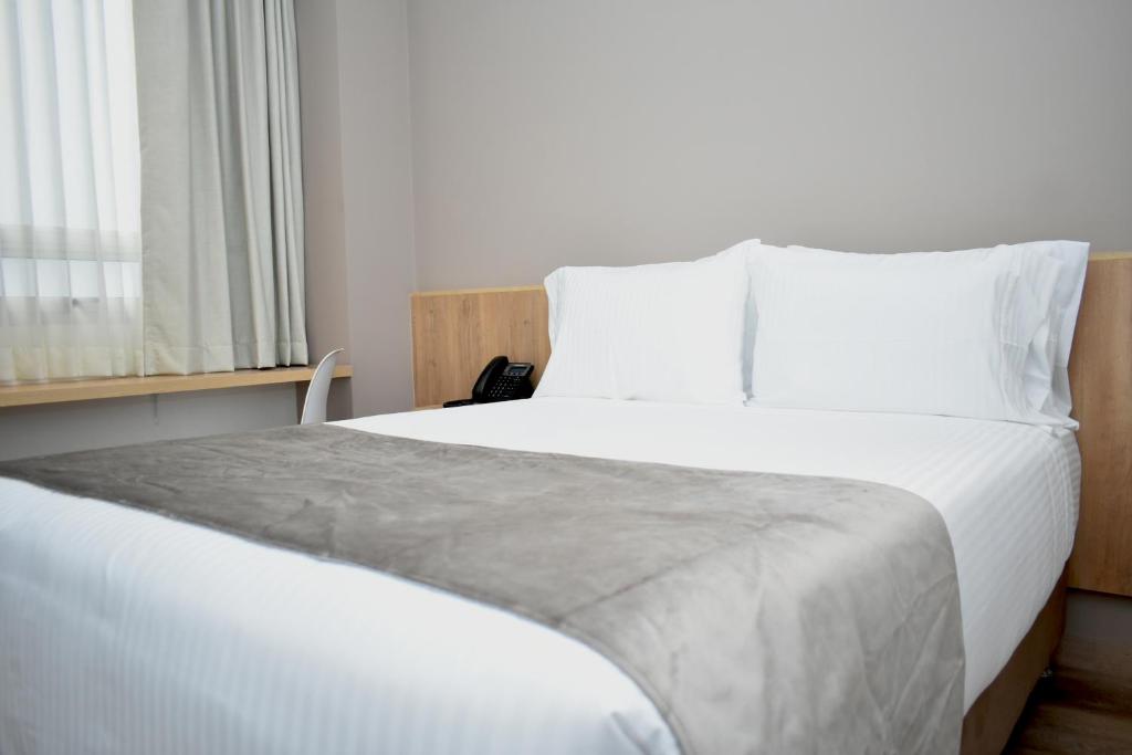 Postel nebo postele na pokoji v ubytování EM Hotel Corferias Embajada Americana