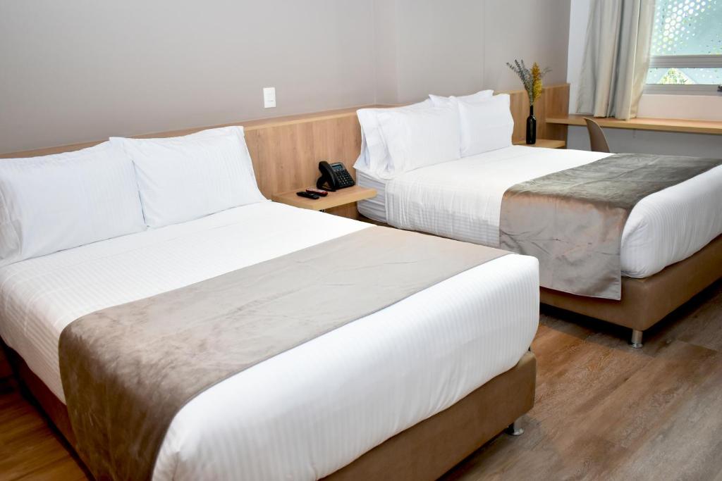 Postel nebo postele na pokoji v ubytování EM Hotel Corferias Embajada Americana