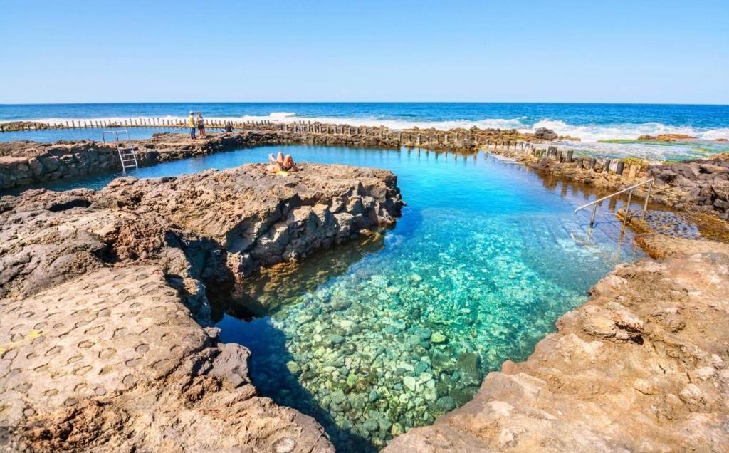 una piscina sulla spiaggia con rocce di Dúplex relax Puerto de las Nieves a Puerto de las Nieves
