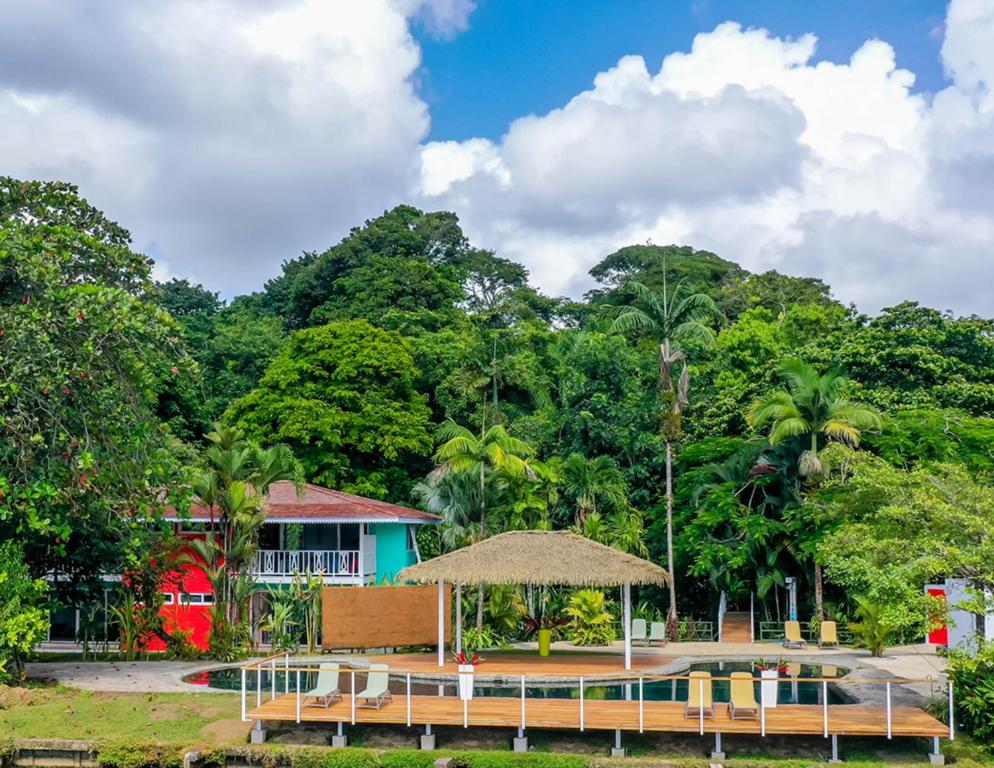 a resort with a table and a building and trees at Tortuga Lodge & Gardens in Tortuguero
