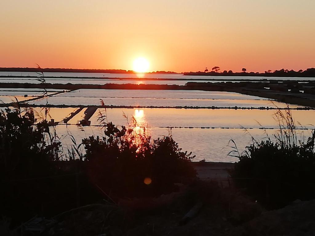 a sunset over a body of water with the sun setting at Casa Vacanze Mirabile in Marsala