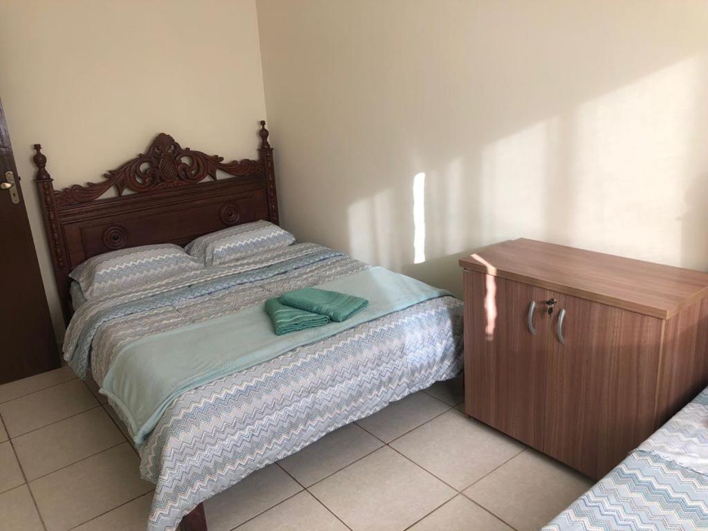 sypialnia z dużym łóżkiem i drewnianą komodą w obiekcie Apartamento com varanda w mieście Lavras