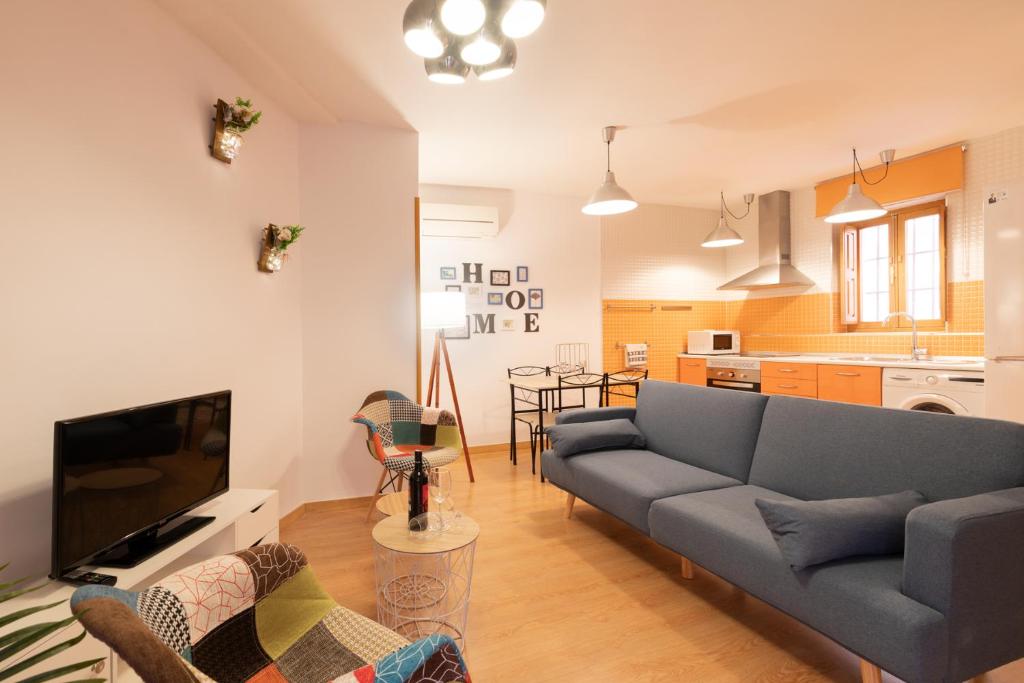 sala de estar con sofá azul y cocina en LA ESQUINA DE ALFONSO XII, en Toledo