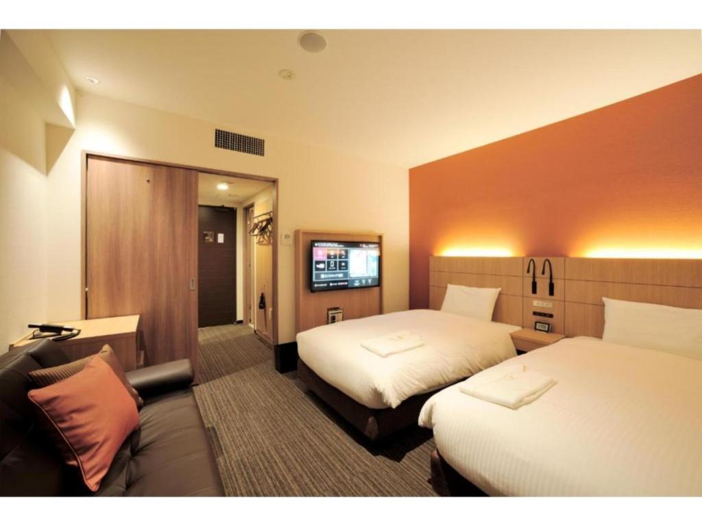 um quarto de hotel com duas camas e uma televisão de ecrã plano em Hotel Nets Sapporo - Vacation STAY 63535v em Sapporo