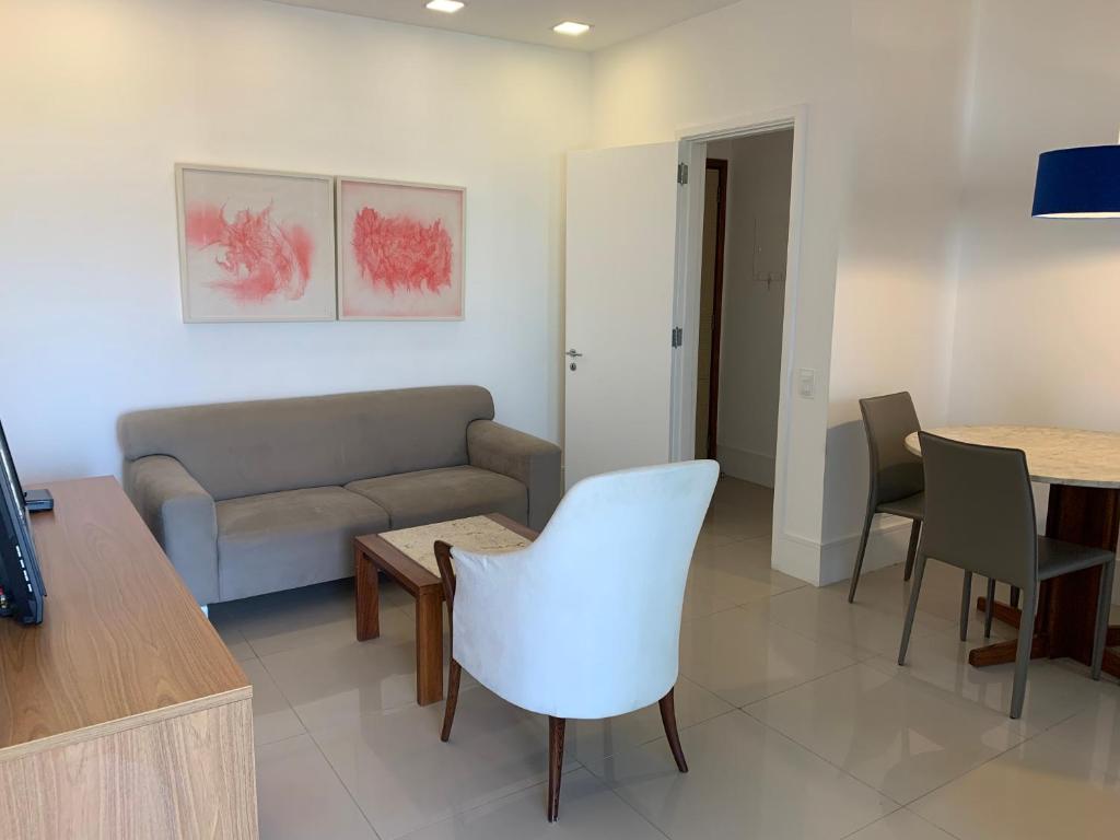 a living room with a couch and a table at Flat com 65 metros; sala; duas suítes; cozinha Recém-reformado in Rio de Janeiro