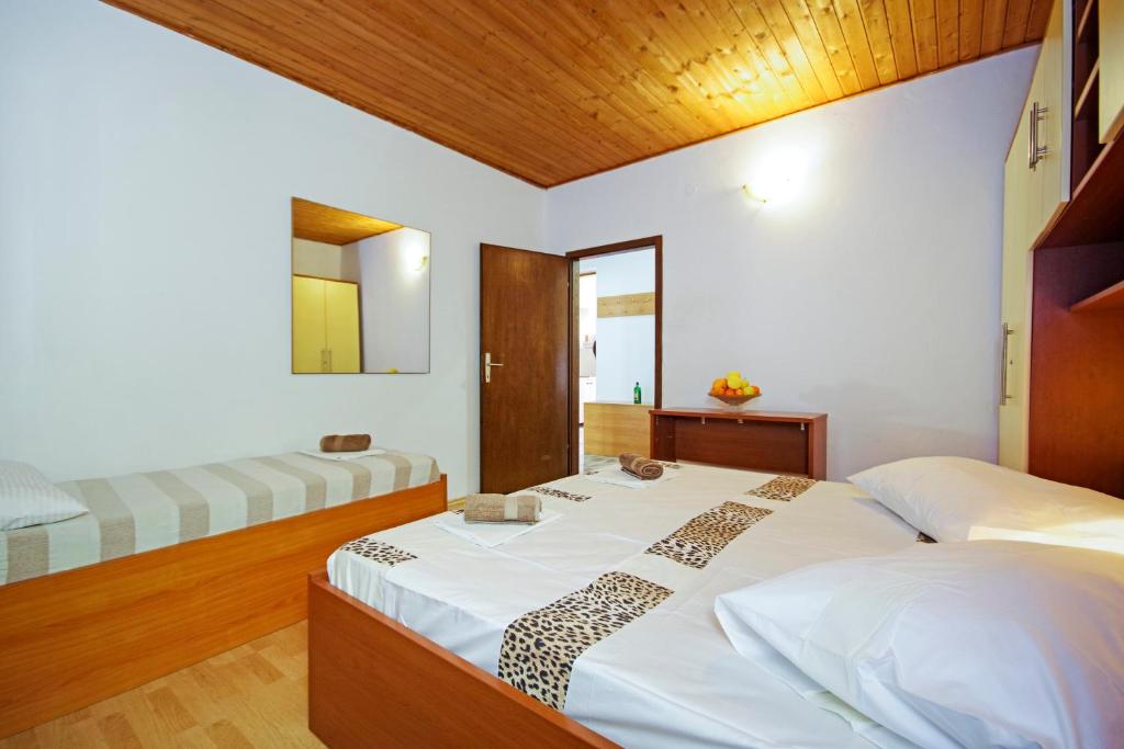 - une chambre avec deux lits et un plafond en bois dans l'établissement Apartmani ANDRIJA, à Živogošće
