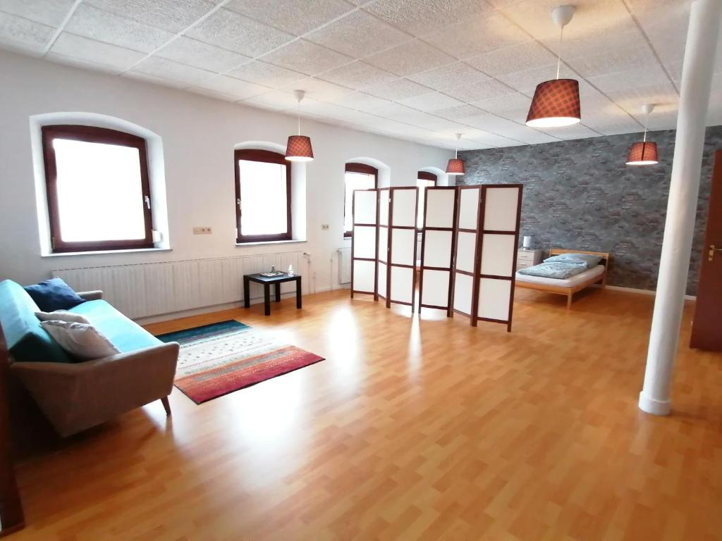 Geräumige Wohnung in zentraler Lage في Emskirchen: غرفة معيشة مع أريكة وطاولة