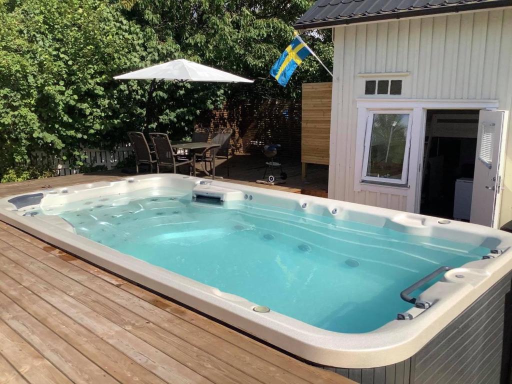 a hot tub on the deck of a house at Cosy compact living with gym access. in Heberg