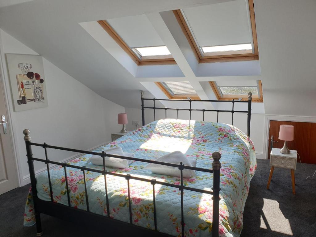 een bed in een kamer met dakramen bij Golden Plover at Plover Cottage Lindley in Huddersfield
