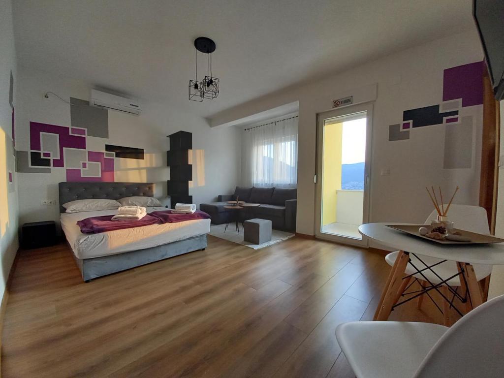 モスタルにあるLuna APARTMANIのベッドとリビングルームのある寝室