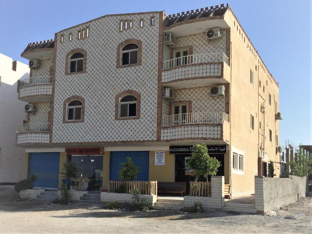 a large brick building with a balcony on it at Lady Queen Apartment in Marsa Alam City