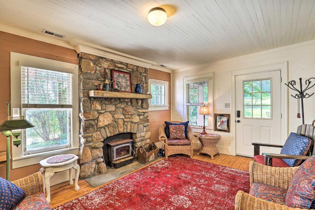 uma sala de estar com lareira de pedra e cadeiras em Momma Rhodes Cozy Home Near Blue Ridge Pkwy em Arden