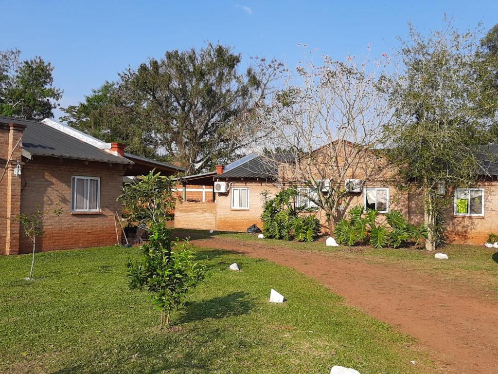 een tuin met twee huizen en een onverharde weg bij Mi Buen Refugio in Puerto Iguazú