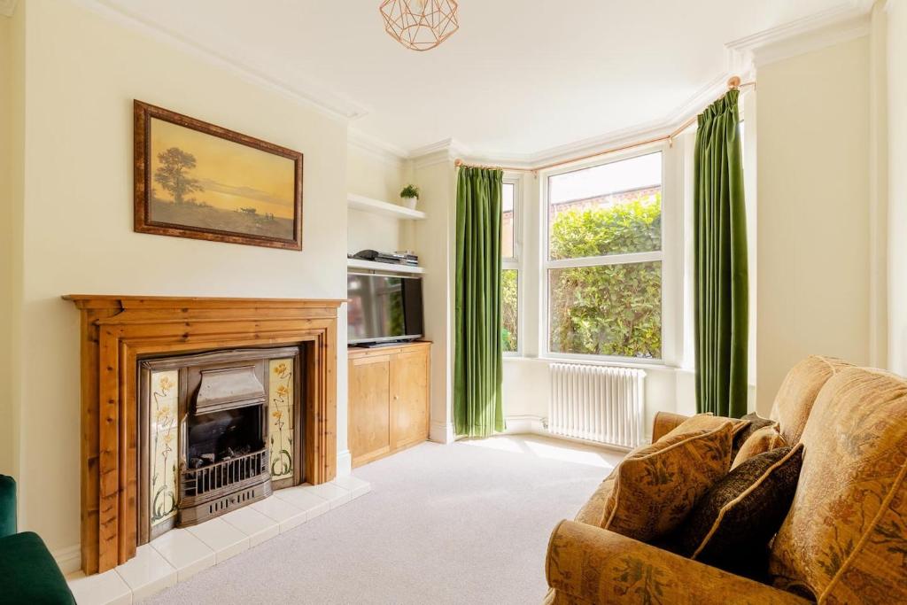 a living room with a fireplace and green curtains at Entire Property in Hoole, Chester- walking distance to train station & city centre in Chester