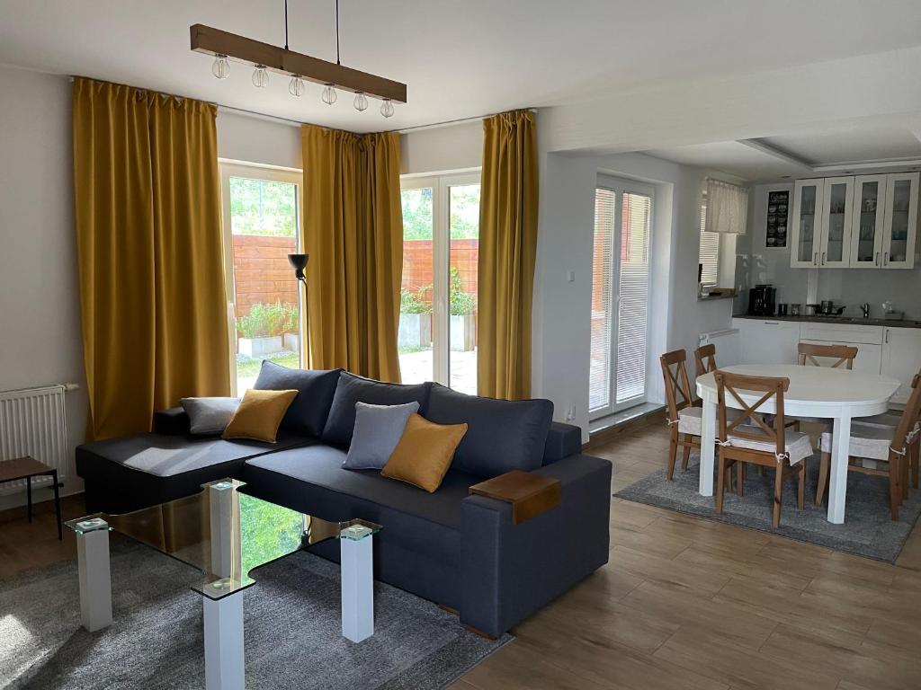 Una sala de estar con un sofá azul y una mesa. en Apartamenty Sielankowo, en Szczyrk