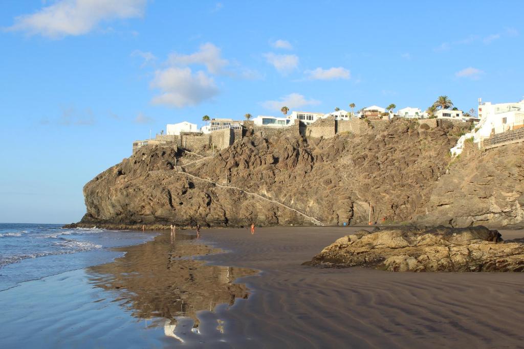 una playa con un castillo en lo alto de un acantilado en Sea View San Agustin by Privilege Bay, en San Agustín