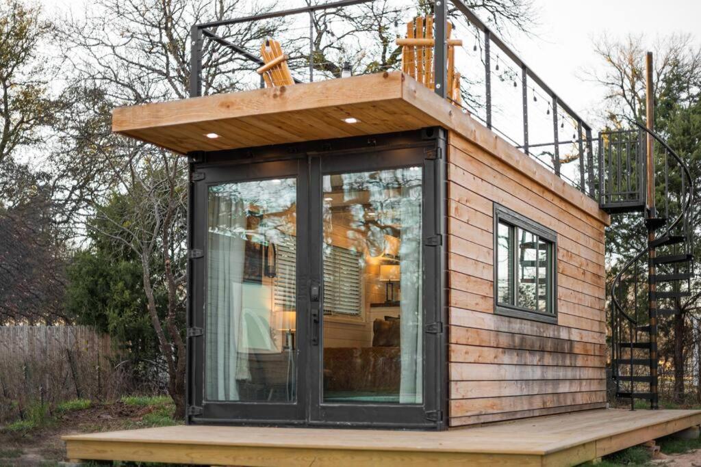 a tiny house with a balcony on top of it at Deer Creek Tiny Container Home-12 Min to Magnolia in Bellmead