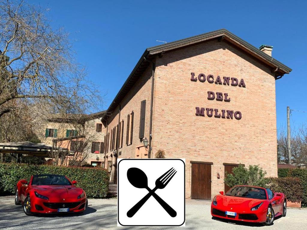 dos coches rojos estacionados frente a un edificio en Locanda Del Mulino, en Maranello