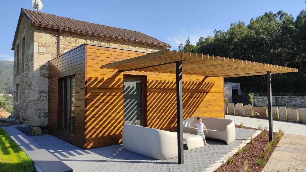 Kobieta stoi przed budynkiem w obiekcie A Casa de Costa w mieście Laxe