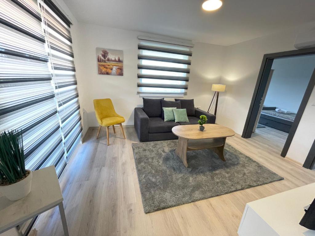 uma sala de estar com um sofá e uma mesa em Ammirevole Ravne Apartments em Visoko