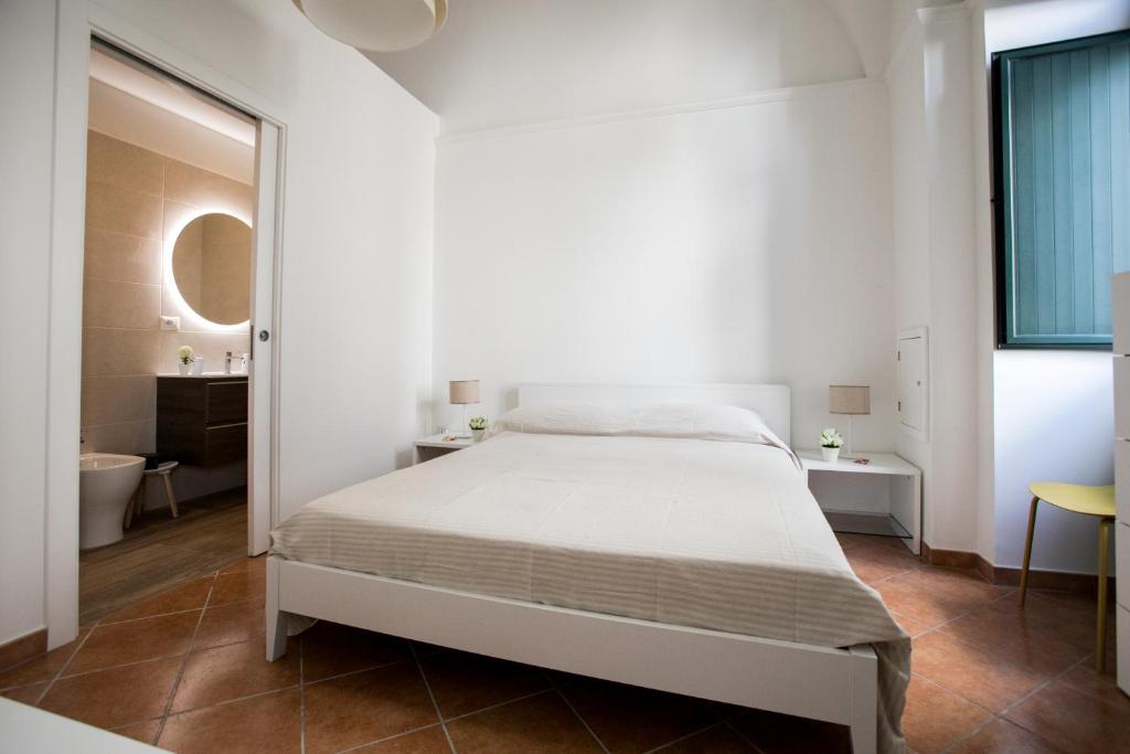Habitación blanca con cama y baño. en Giulia's House, en Galatina