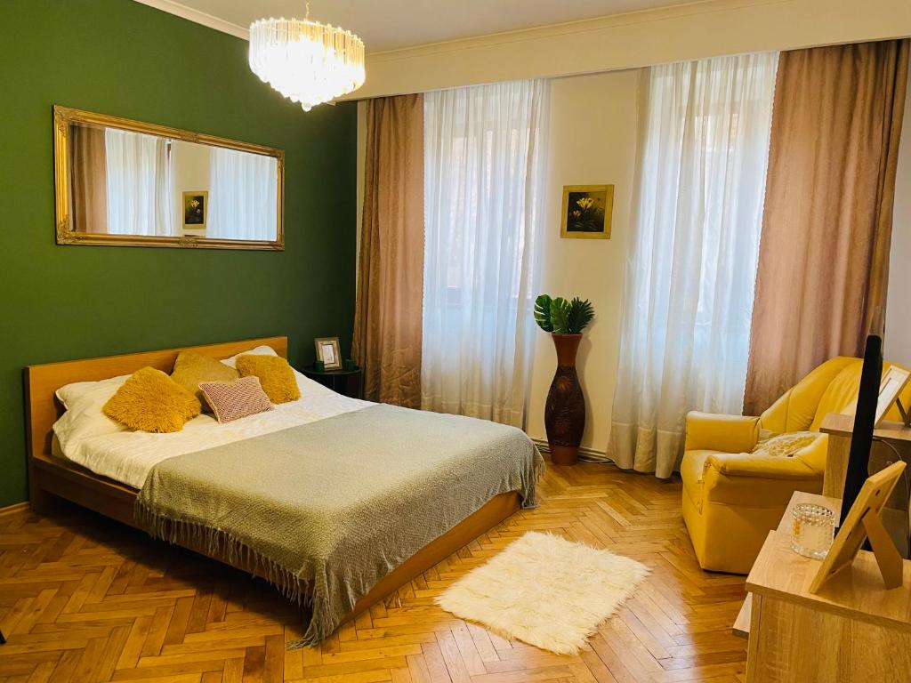 a green bedroom with a bed and a chair at Postavarului Apartment in Braşov