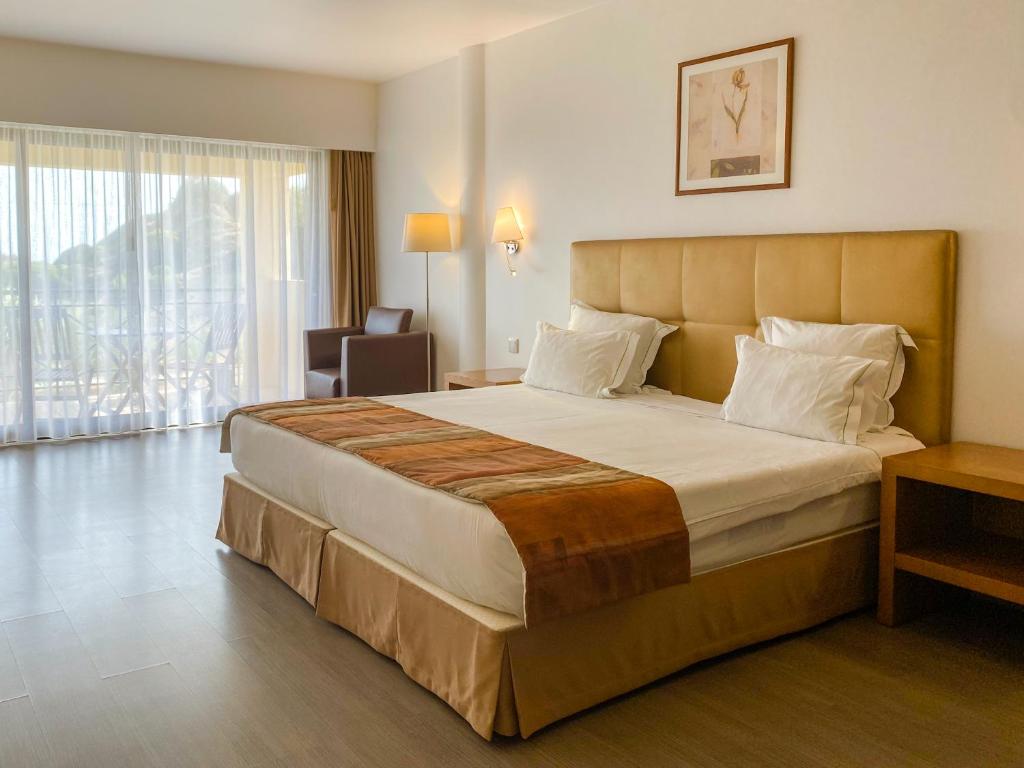 ein Schlafzimmer mit einem großen Bett in einem Hotelzimmer in der Unterkunft Foz Club - Algarve in Alvor
