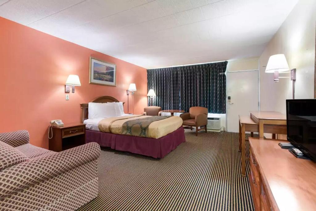 een hotelkamer met 2 bedden en een bank bij Royal Inn Clearfield in Clearfield