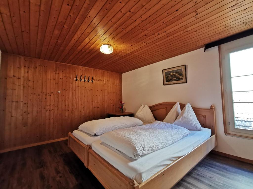 Bett in einem Zimmer mit Holzdecke in der Unterkunft Interlaken apartment 27 in Interlaken