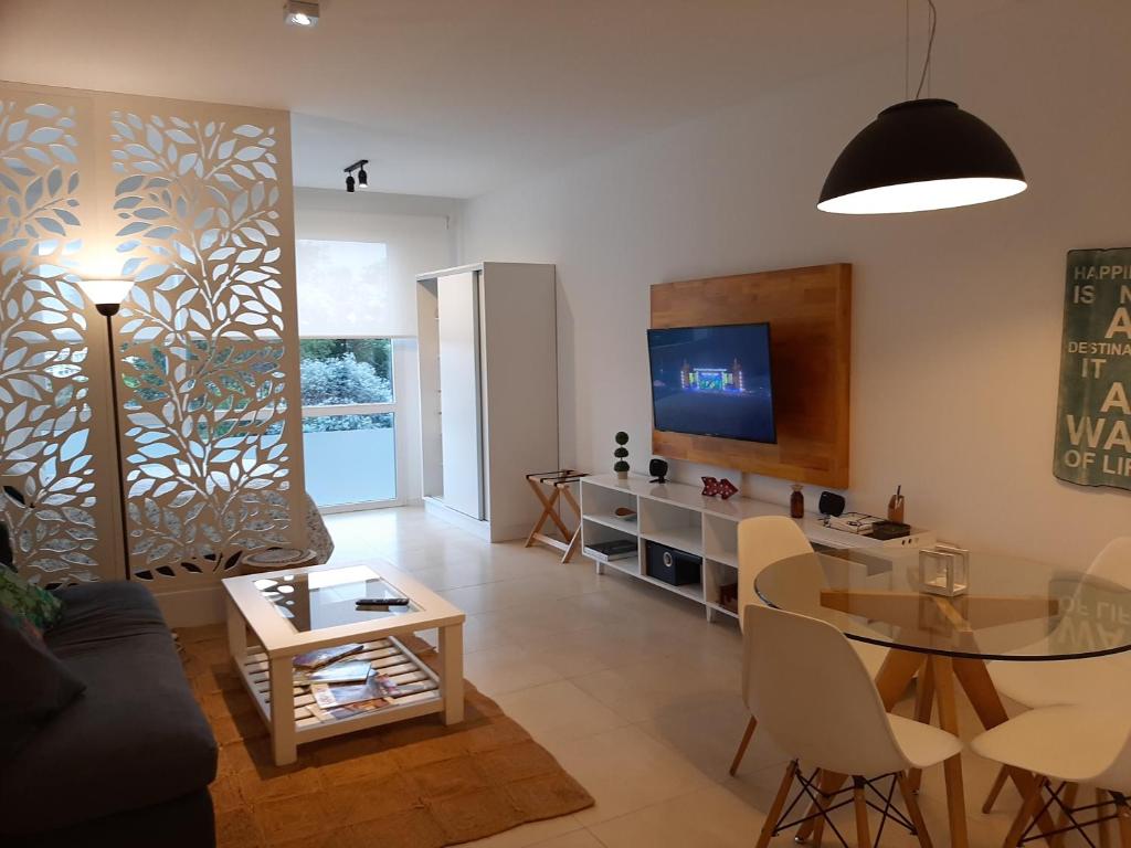 a living room with a glass table and a television at Bahía Grande Nordelta - con Cochera in Benavídez