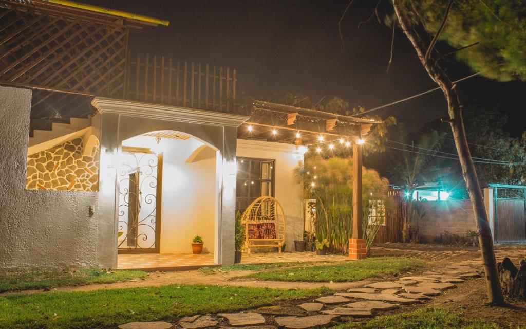 een huis met lichten aan de zijkant 's nachts bij Hotel Taa' Tiin in San Juan La Laguna