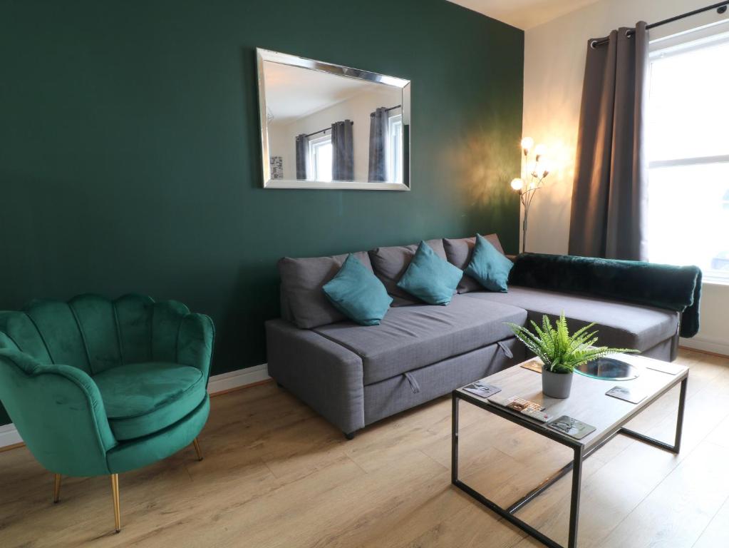 ein Wohnzimmer mit einem Sofa und einem Stuhl in der Unterkunft Sea Nest in Torquay