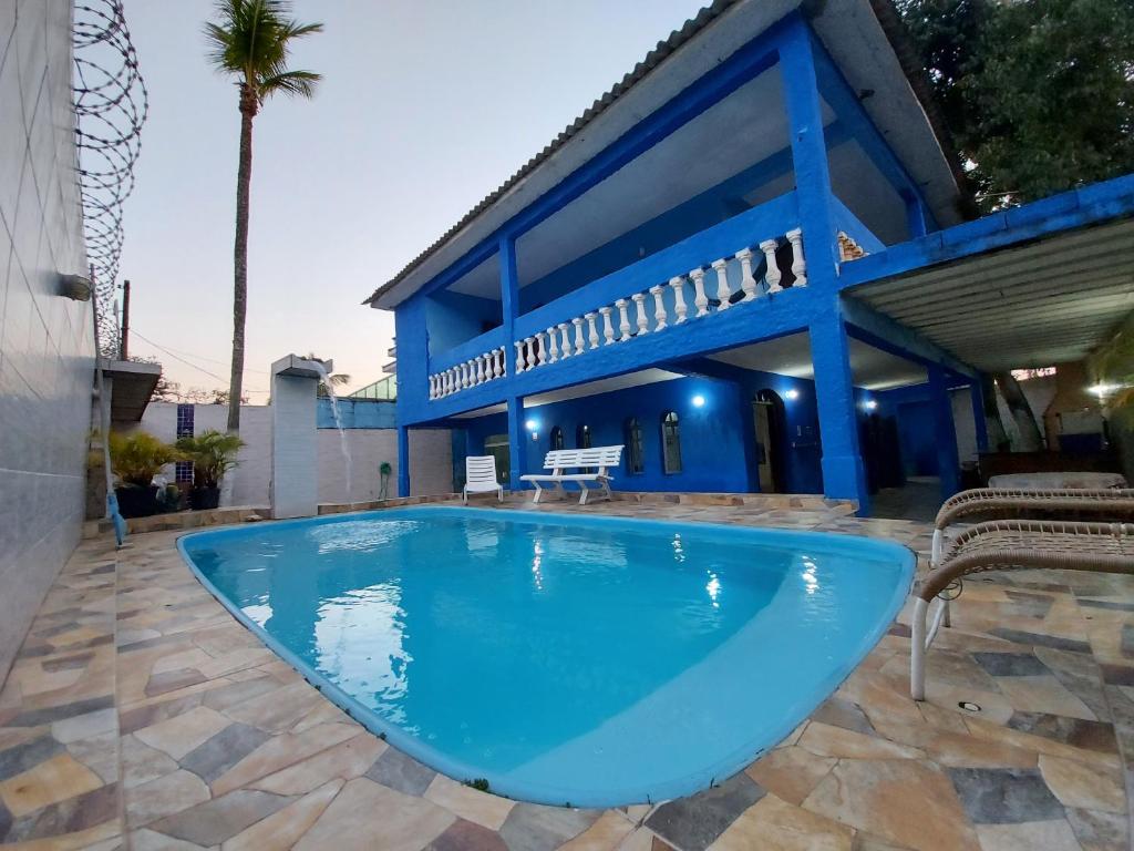 una gran piscina azul frente a un edificio en Casa Praia do Pernambuco, en Guarujá