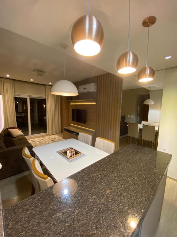 a kitchen and living room with a table and chairs at Apartamento em Gramado com piscina in Gramado