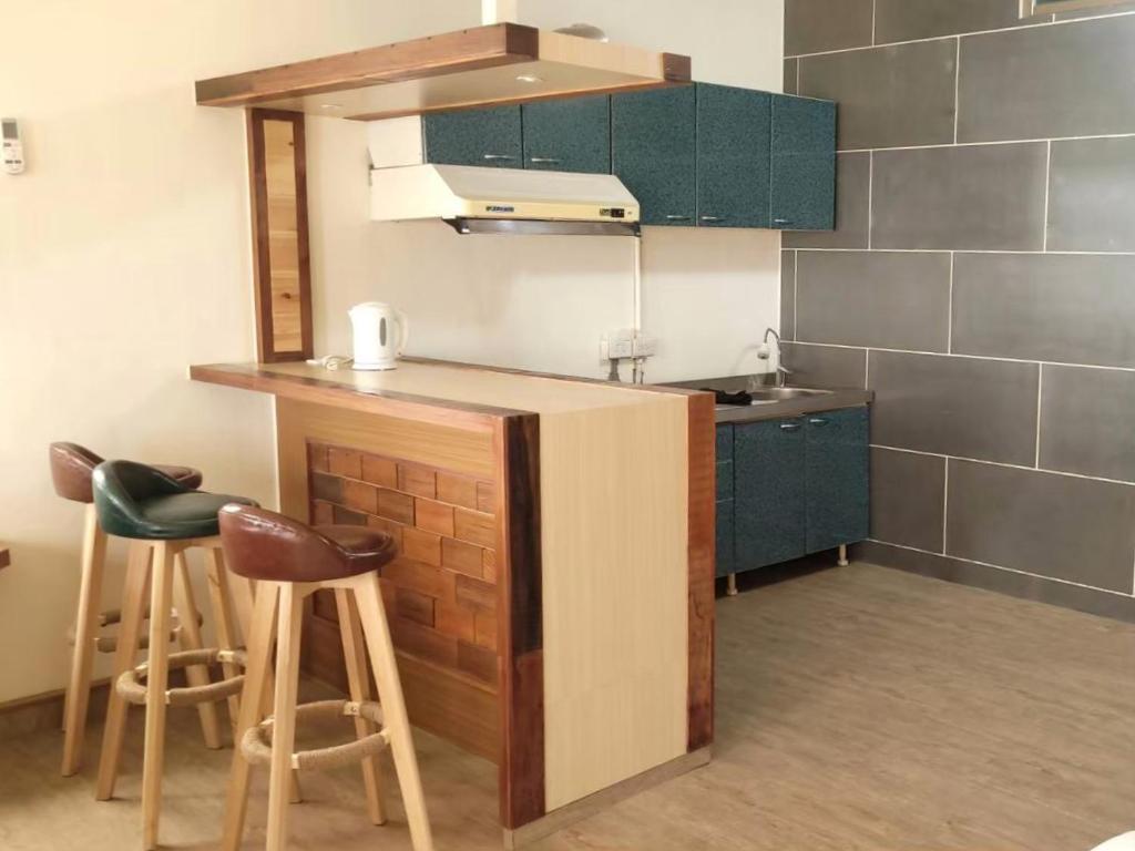 a kitchen with a counter and stools in a room at Runners&#39; House Taitung in Changbin