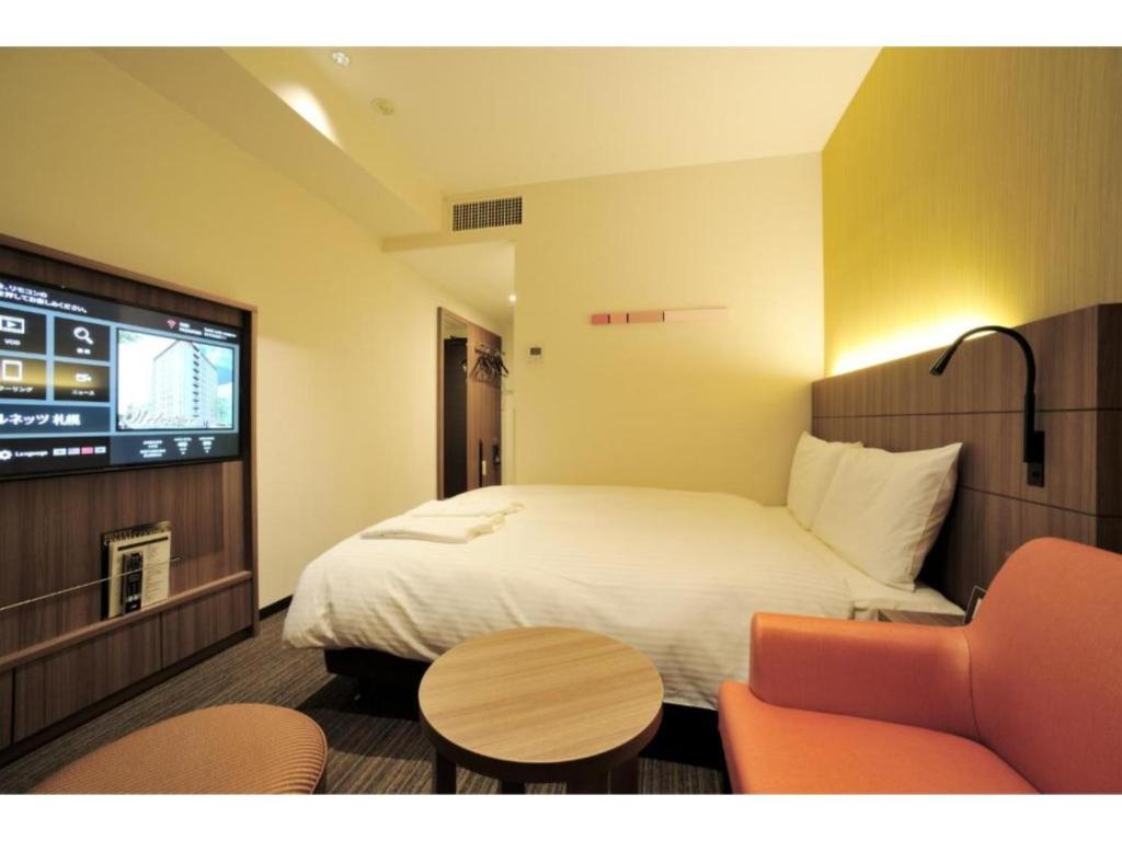 札幌市にあるHotel Nets Sapporo - Vacation STAY 63536vのベッド1台、薄型テレビが備わるホテルルームです。