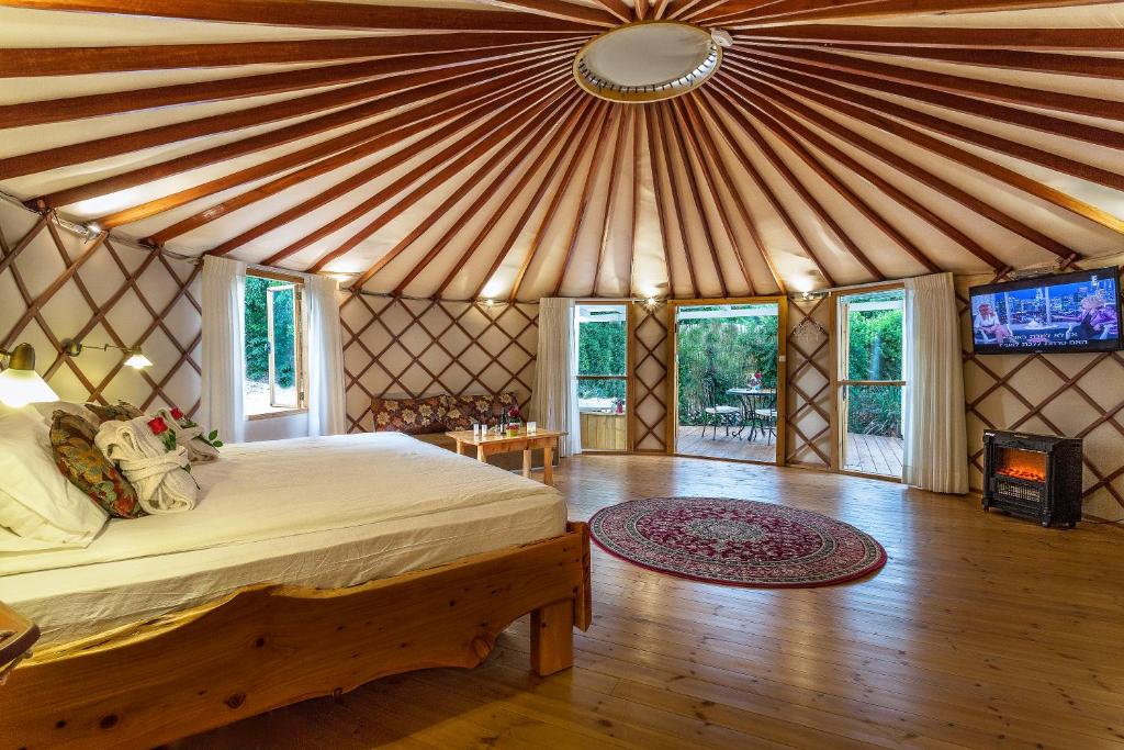 a bedroom with a bed in a yurt at Helios Luxury Suites in Had Nes