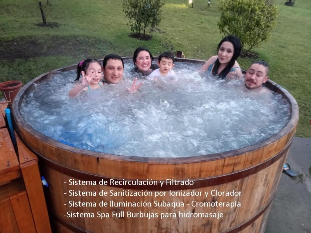 a group of people in a jacuzzi in a barrel at Cabañas Mis Viejos in Panguipulli