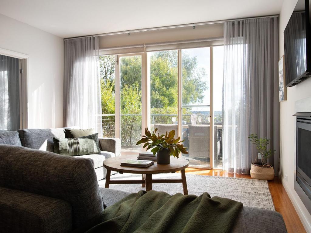 a living room with a couch and a table at Dahlia in Daylesford