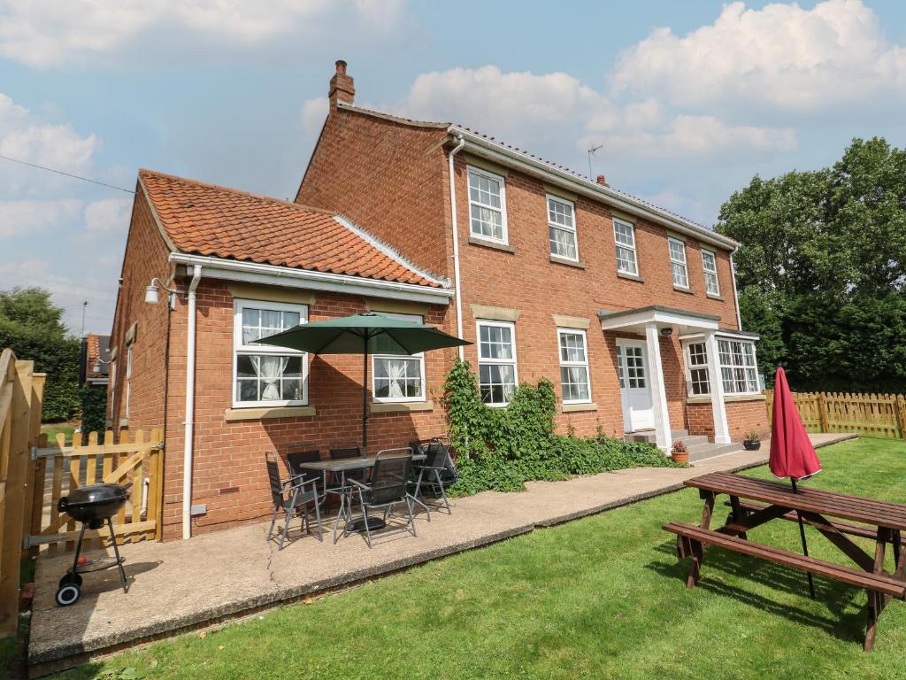 a house with a table and chairs and an umbrella at Woodhill in Bentley