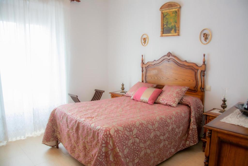 a bedroom with a bed with a pink comforter at Casa Rural Nijata in Valencia del Mombuey