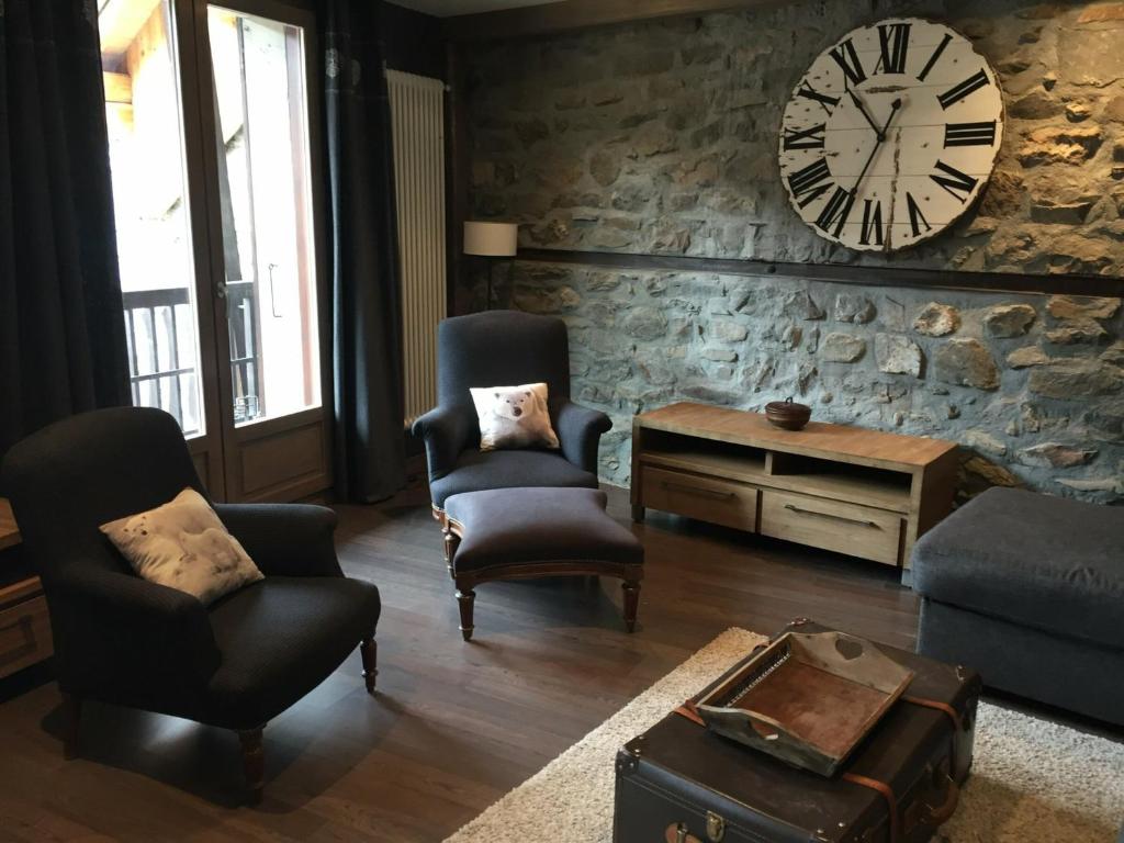 sala de estar con 2 sillas y reloj en la pared en Appartement Valloire, 4 pièces, 8 personnes - FR-1-263-214, en Valloire