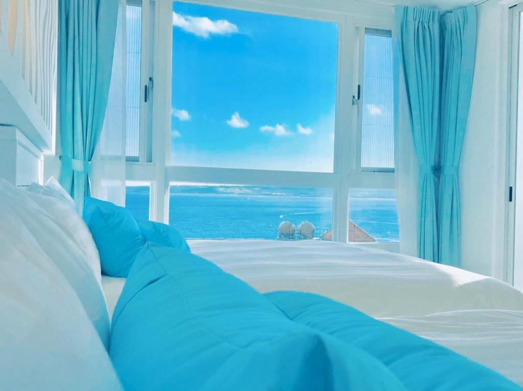 a bedroom with a bed with a view of the ocean at Sky Grass in Nanwan