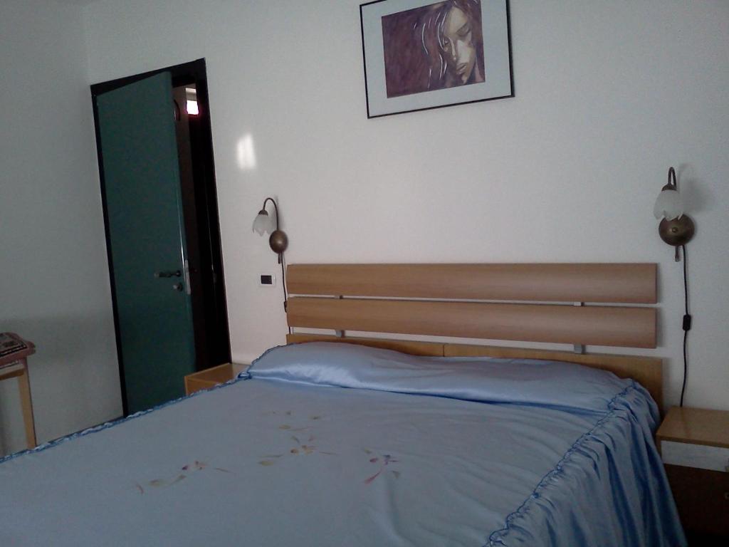 トレントにあるB&B Trento Nordのベッドルーム1室(ベッド1台、鏡、ドア付)