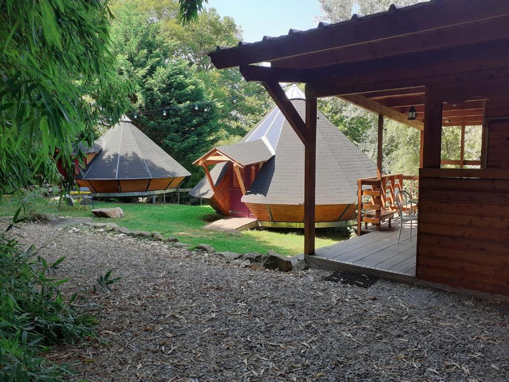 un grupo de tiendas de campaña en un patio con terraza en Tipis Du Petit Buisson en Saint-Antonin-de-Lacalm