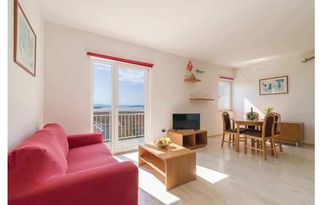 ein Wohnzimmer mit einem roten Sofa und einem Tisch in der Unterkunft Apartment RED in Vodice