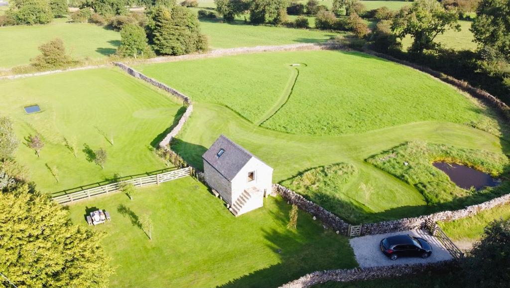 an aerial view of a house on a green field at Little Barn Peak District in Leek