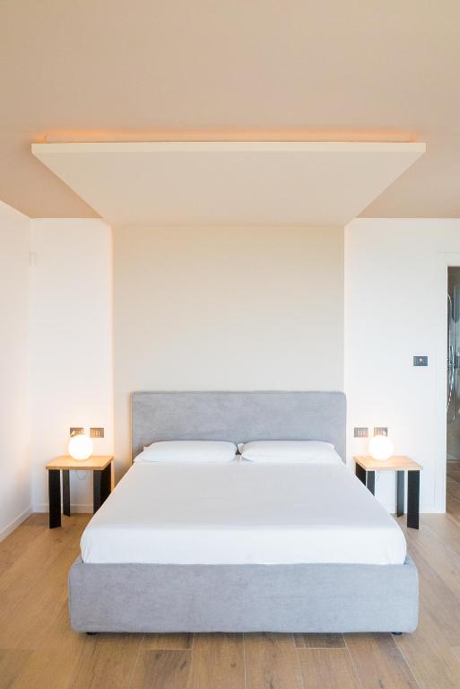 a large bed in a room with two tables at Encanto Agriturismo & Private SPA in Visogliano